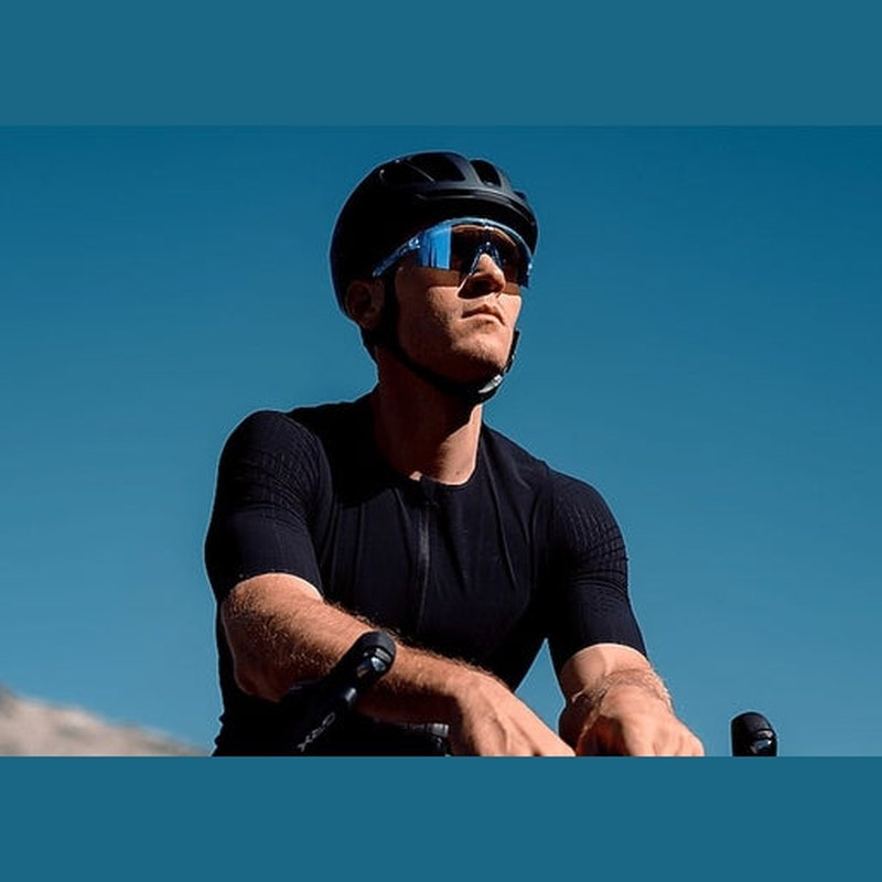 Cyklist som bär Bliz P006 solglasögon med blått glas mot klarblå himmel