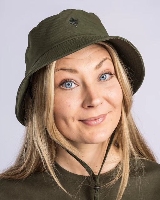 Närbild på mörkgrön InsectSafe hatt med träemblem och justerbart hakband