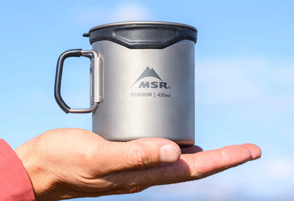 Håller MSR Titan-kopp mot blå himmel, 450 ml