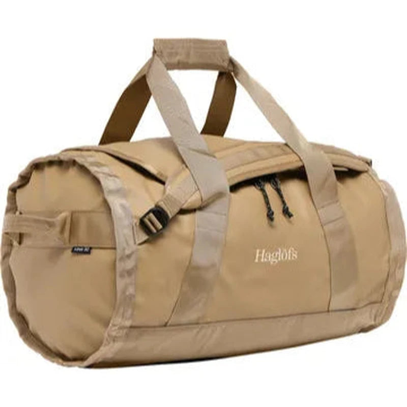 Beige Haglöfs Lava 50L duffelväska i trekvartsprofil med handtag och dragkedja