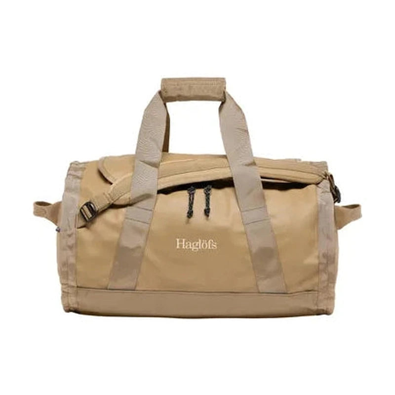 Framsida av beige Haglöfs Lava 50L duffelväska med dubbla handtag och logotyp
