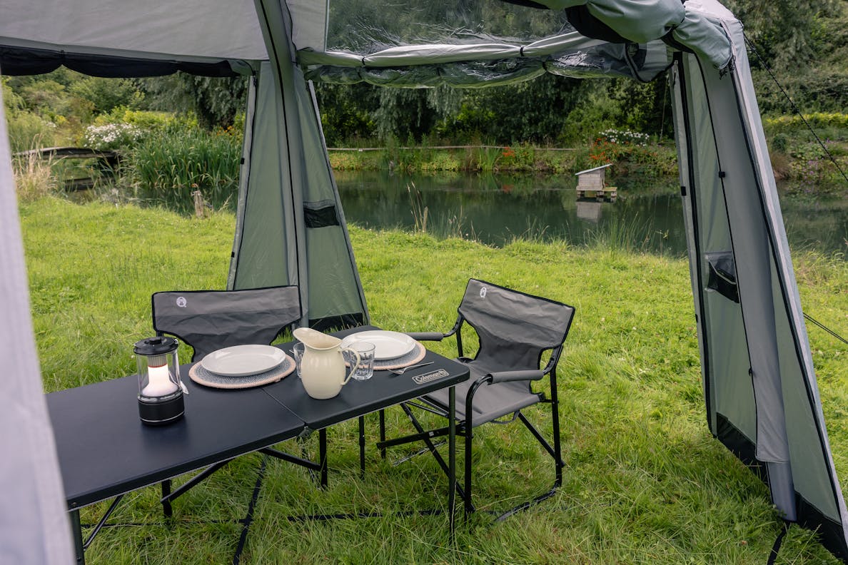 Campingbord vid sjön inrett med stolar och servering