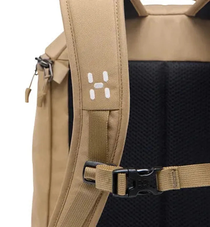 Närbild axelrem beige ryggsäck med H-logotyp, justerspänne och mesh-ventilering