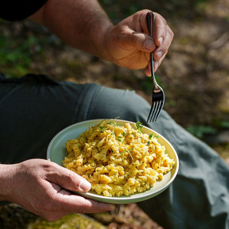 Person äter frystorkad pasta utomhus