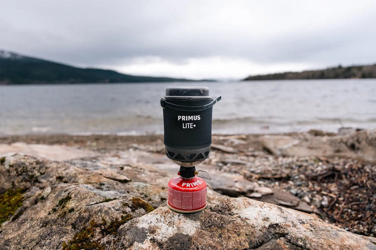 Utomhus Primus gaskök på sten vid vatten