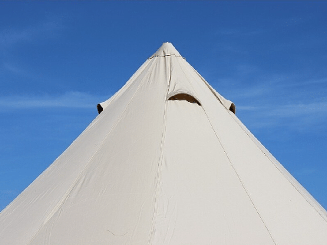 Takspets och ventilering på beige Fjällmark tält mot blå himmel