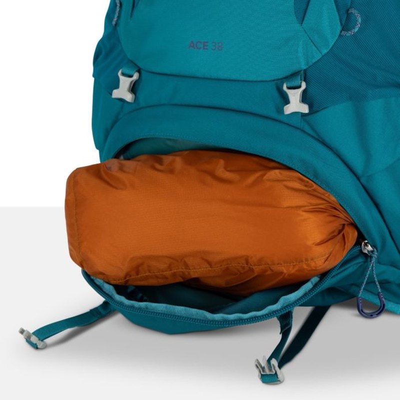 Nedre del av teal Osprey Ace 38 med utdraget sovfiltfack och dragkedjor
