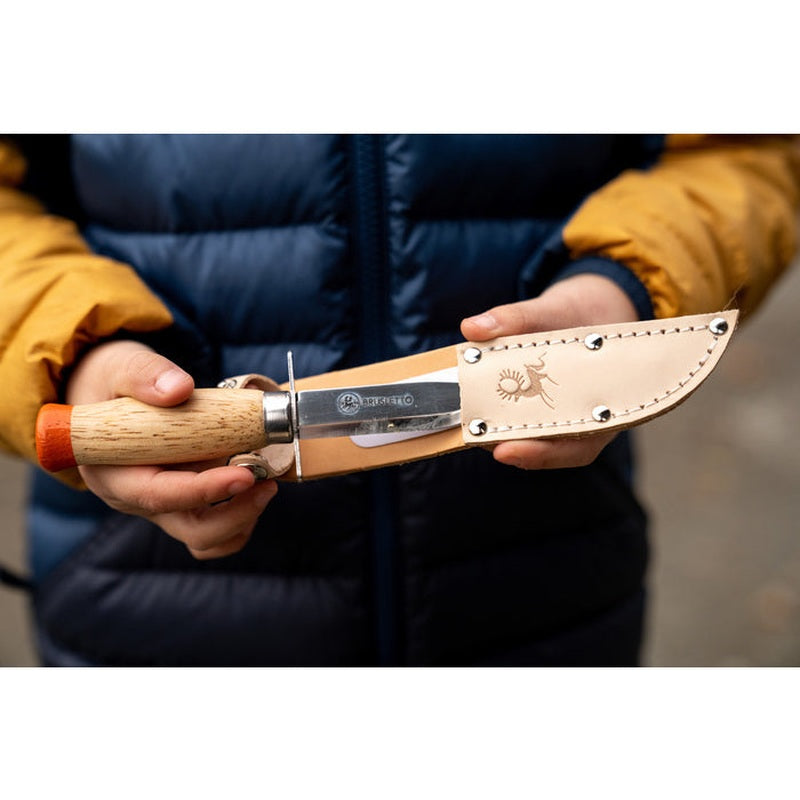 Barn håller Brusletto Scoutkniv i beige lädersheath med silvernitar