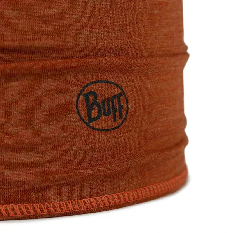 Närbild på orangebrun merinoull-textur med svart Buff-logotyp och omsluten nederkant