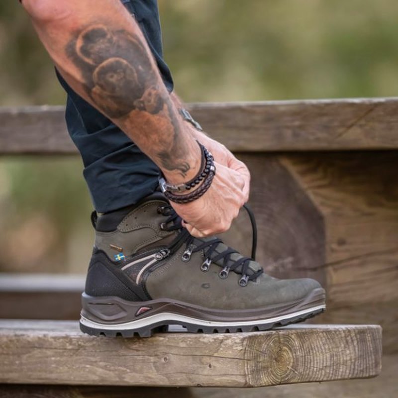 Nubuck-känga på fot vid knäböj på trästomme
