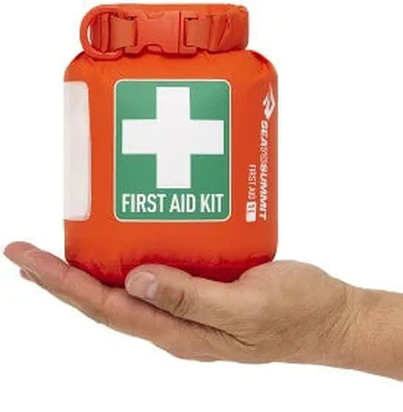 Orange Sea to Summit first aid dry bag held in hand with green label