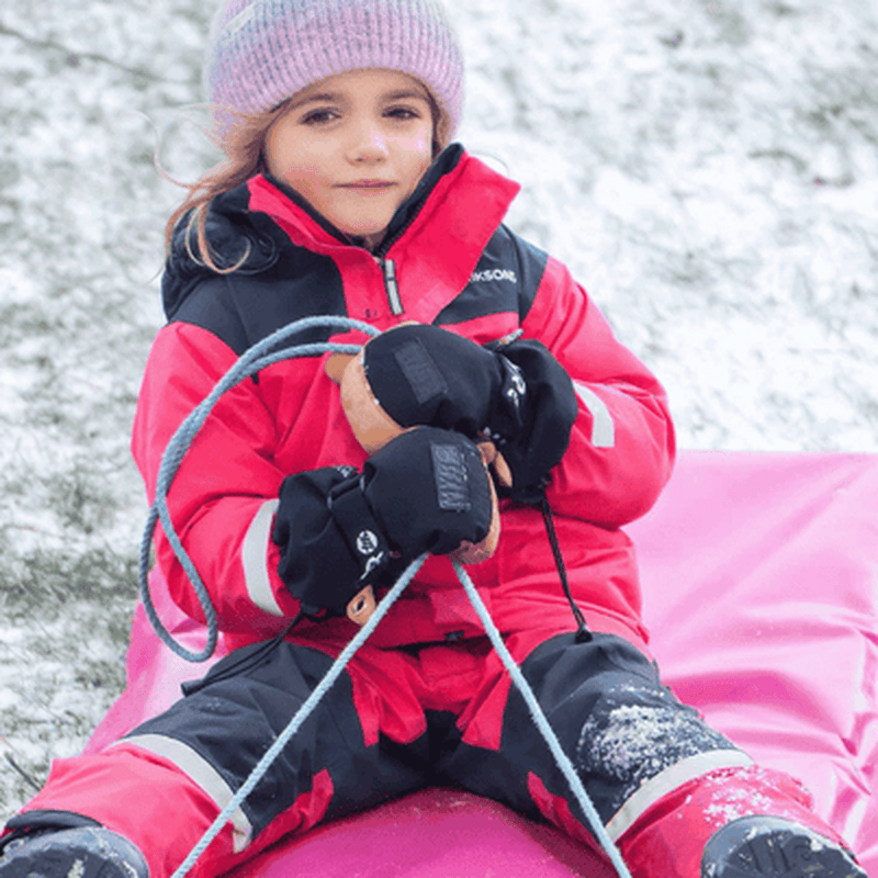 Barn i svarta Videmyr skidhandskar med beige handflator som leker i snö
