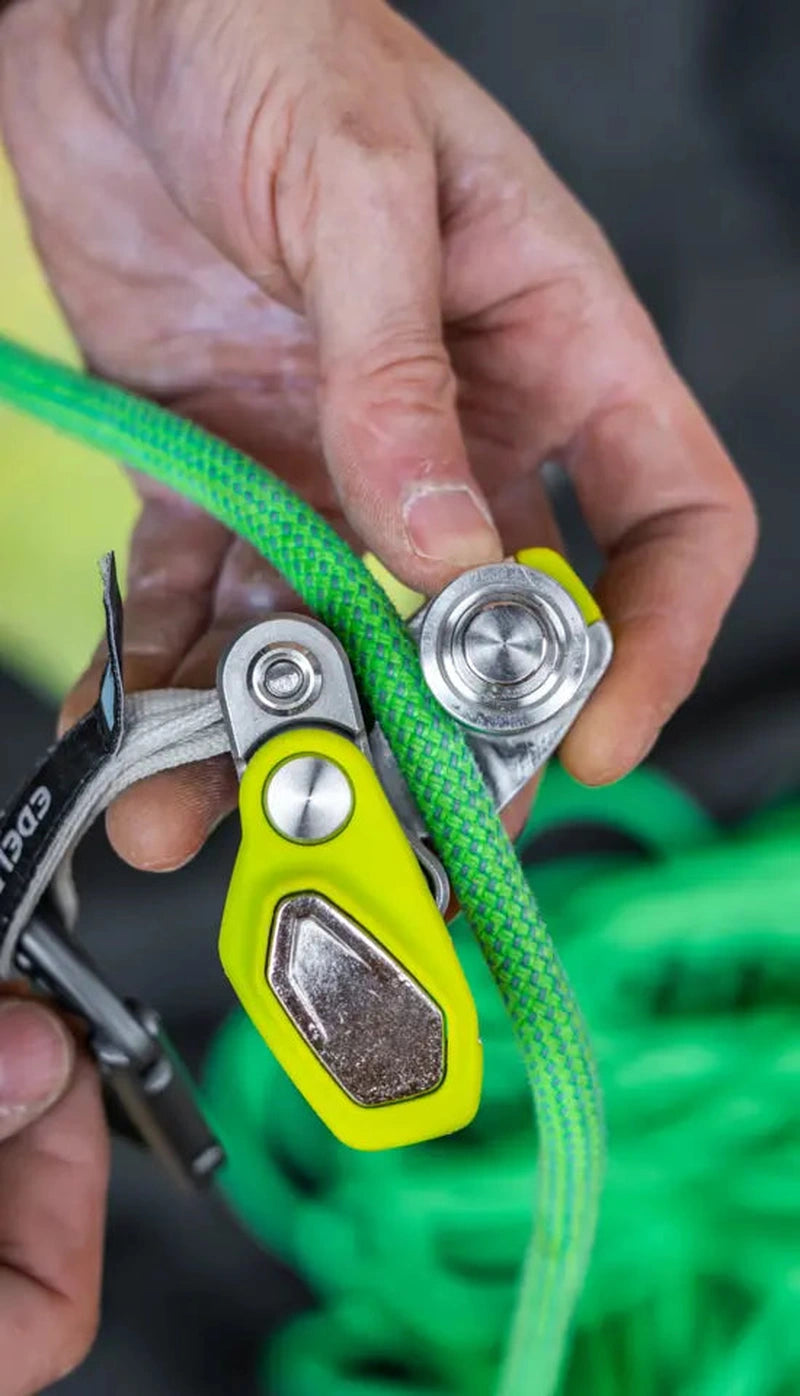 Närbild på hand som hanterar Edelrid OHMEGA broms och rep